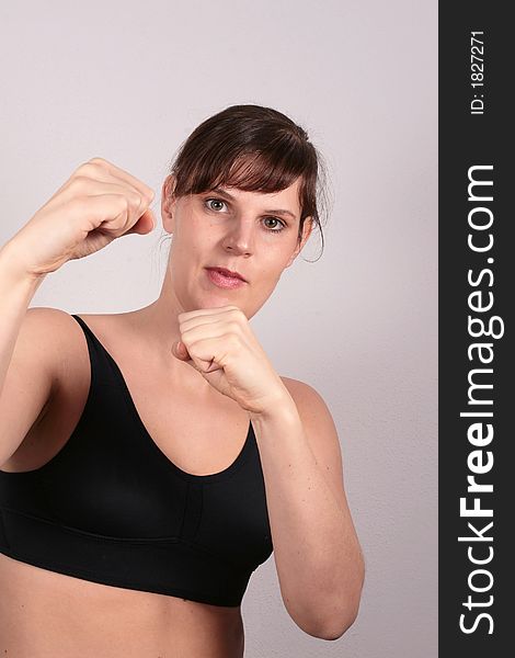 A young white woman is showing her fists in a boxer pose. A young white woman is showing her fists in a boxer pose.