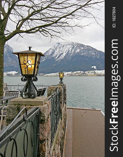 A couple of lit lamps on a lake-front baluster. A couple of lit lamps on a lake-front baluster