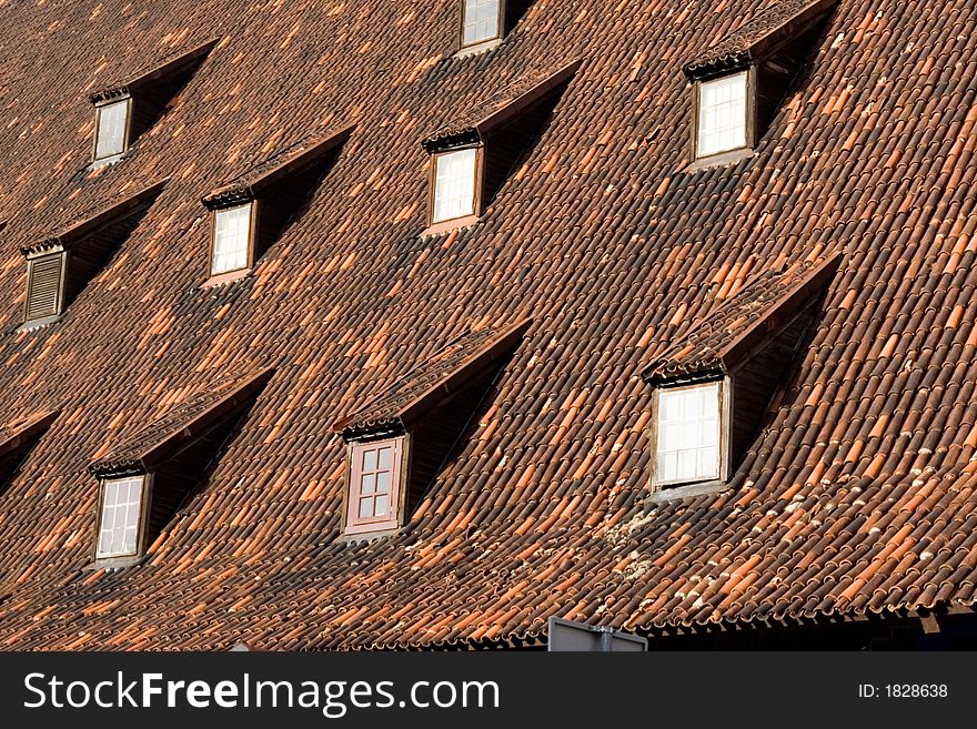 Old tiled red ceramic roof with windows. Old tiled red ceramic roof with windows