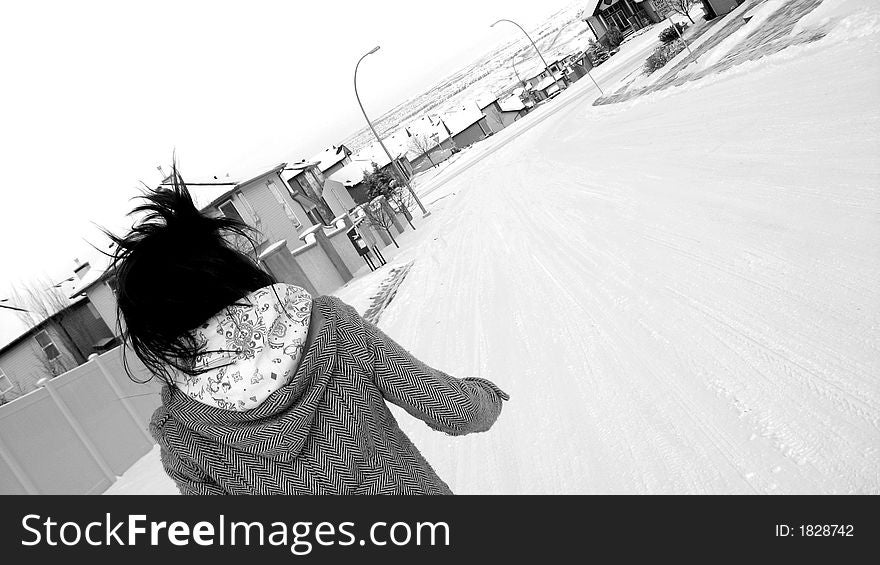 A young woman running down a snow covered street. A young woman running down a snow covered street