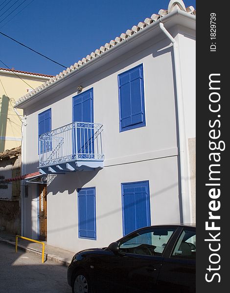 Facade of traditional greek house with balcony and shutters