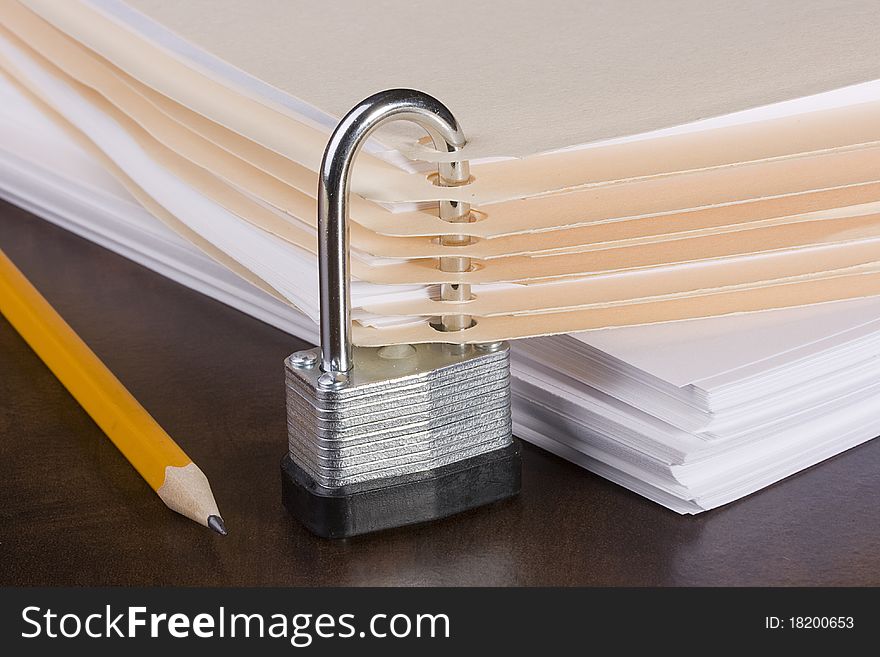 Stack of folders closed by a metal lock. Stack of folders closed by a metal lock.