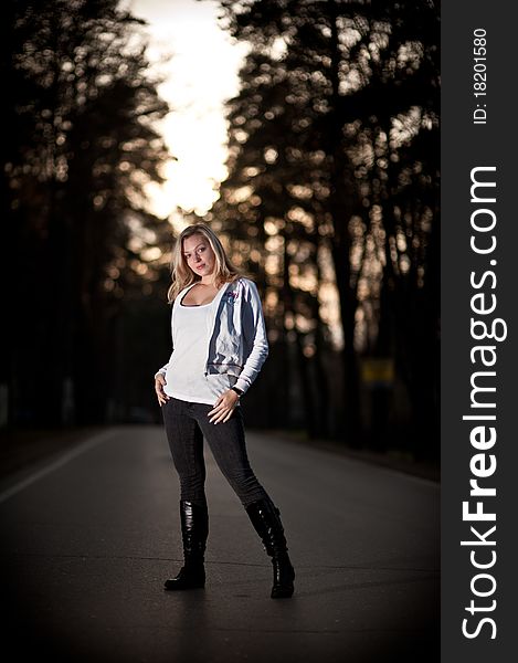 Portrait of a beautiful blonde woman with long hair and a smile on the road in the forest. Portrait of a beautiful blonde woman with long hair and a smile on the road in the forest