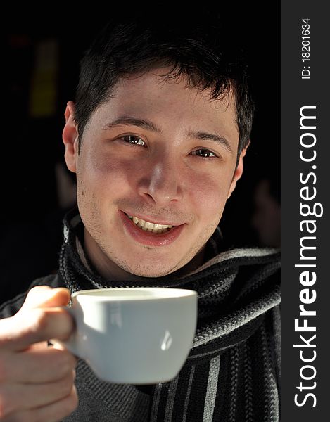 Young man enjoying a cup of coffee. Young man enjoying a cup of coffee