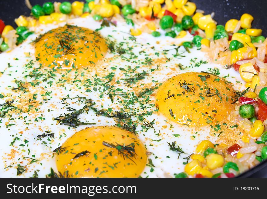 Fried eggs with vegetables, close-up