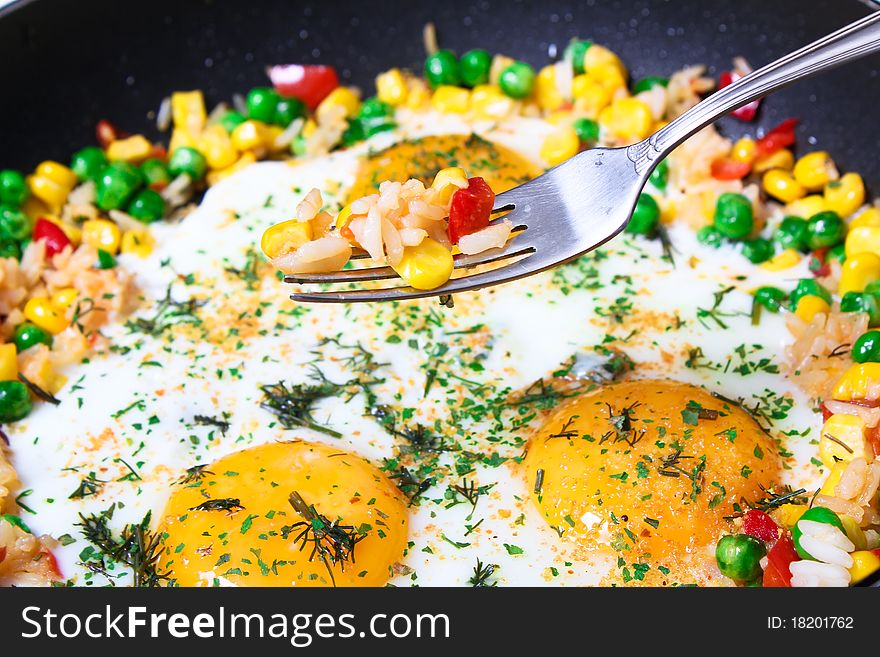 Fried eggs with vegetables, close-up