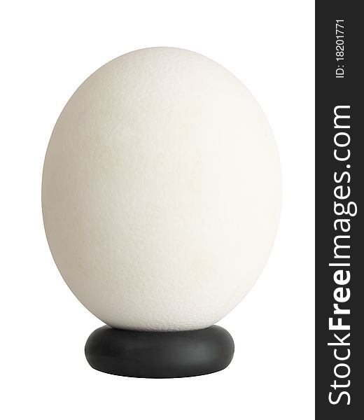 Textured white ostrich egg on black stand isolated on white background. Textured white ostrich egg on black stand isolated on white background