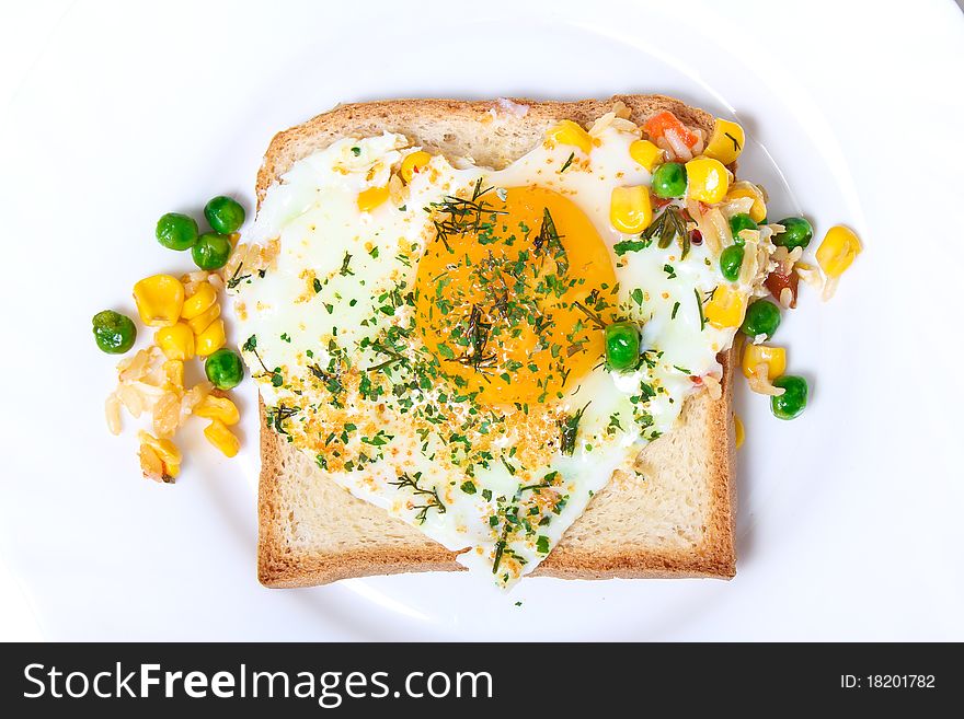 Fried egg on toast bread on a white plate, top-view