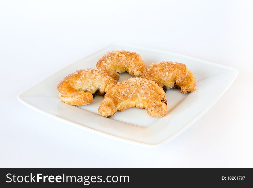 Four fresh golden brown croissants on white plate and isolating background. Four fresh golden brown croissants on white plate and isolating background