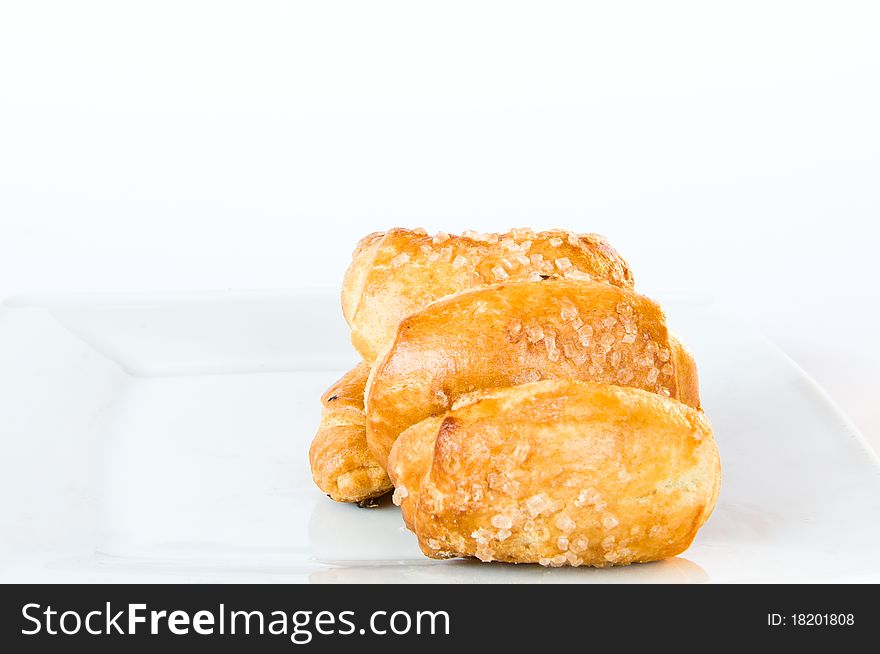 Four fresh golden brown pastry on white plate and isolating background. Four fresh golden brown pastry on white plate and isolating background