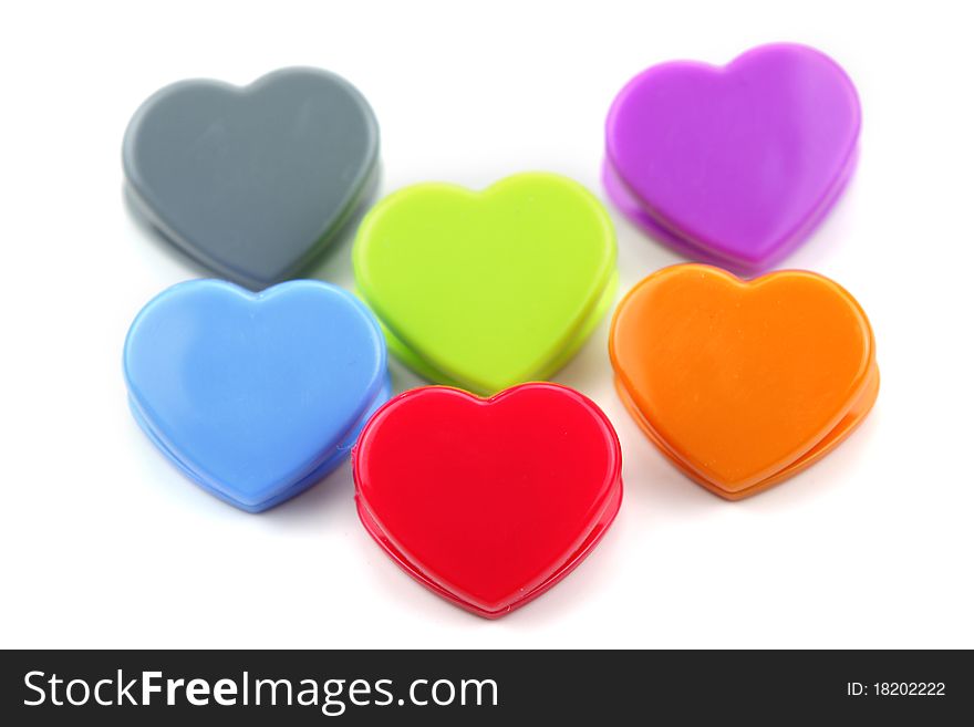 Colorful heart shaped paper clips arranged on white background