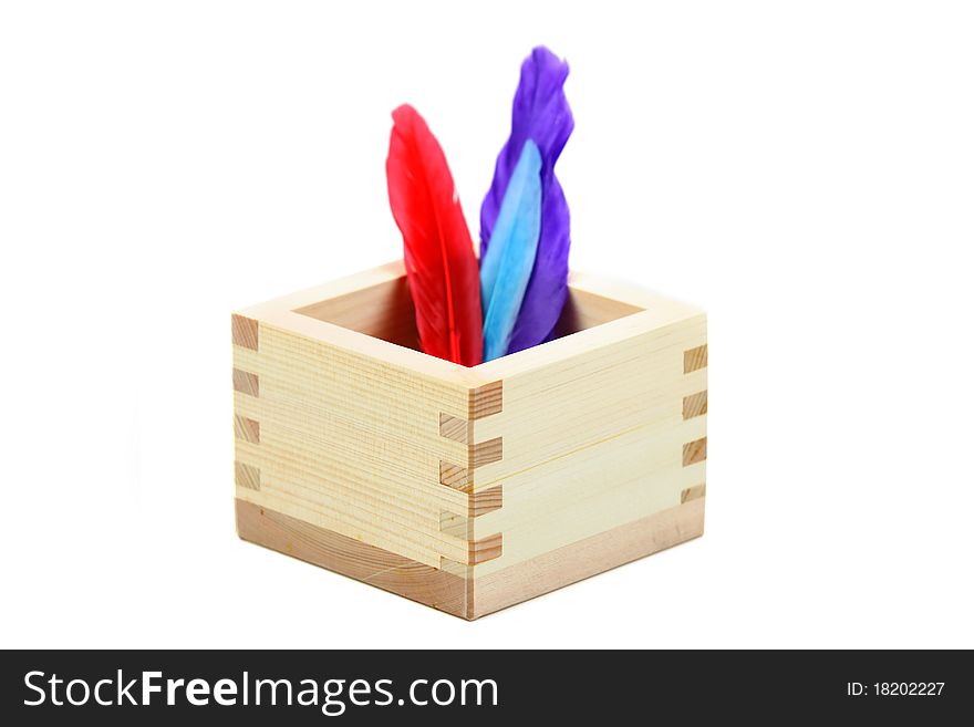 Colorful feathers in a oriental wooden box. Colorful feathers in a oriental wooden box