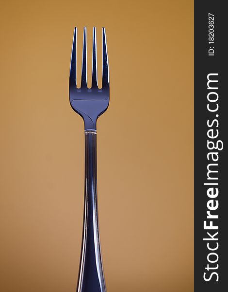 Traditional stainless dishware - fork on clolour background. Selective focus.