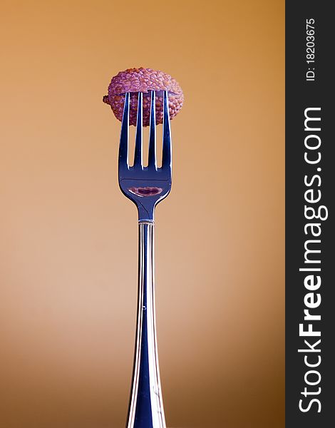 Lichee fruit on fork. Studio shot with selective focus. Lichee fruit on fork. Studio shot with selective focus.