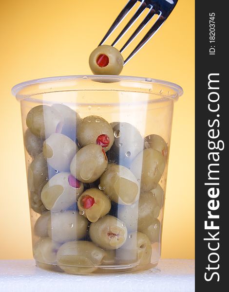 Olives with red pepper in box. Fork on the top. Studio shot. Olives with red pepper in box. Fork on the top. Studio shot