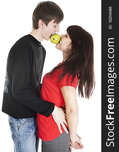 Cheerful young couple eats one apple