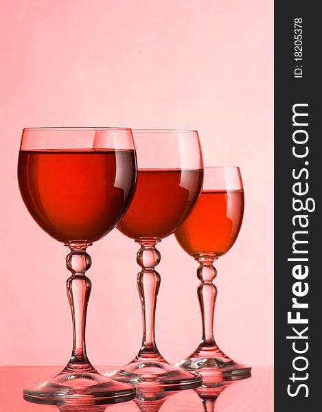 Wine glasses with wine on a pink background