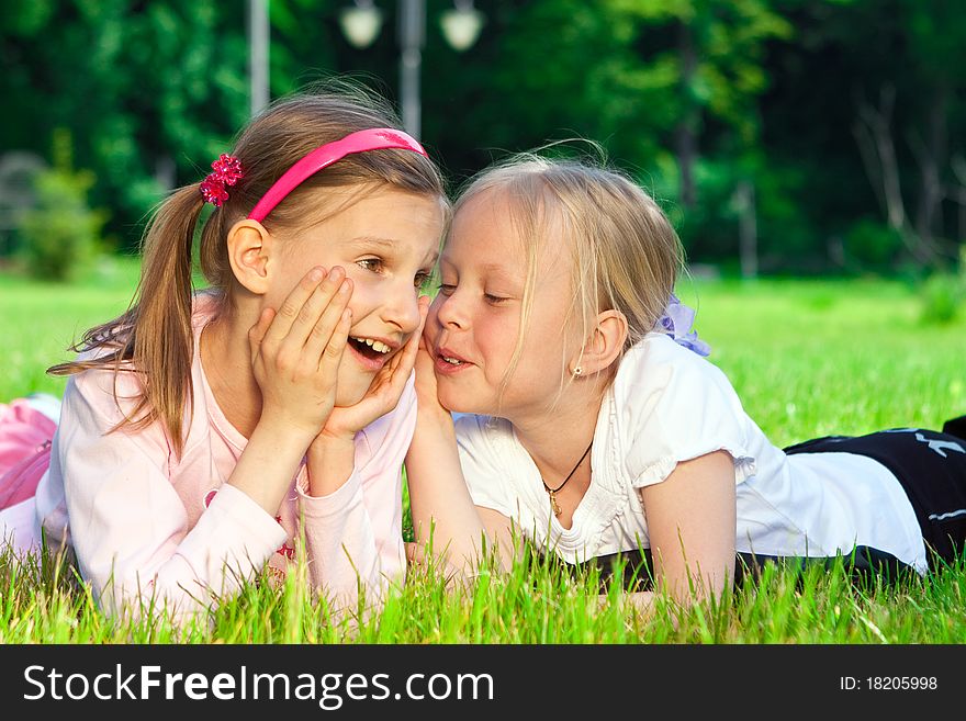 Two pretty young girls sharing a secret together. Two pretty young girls sharing a secret together