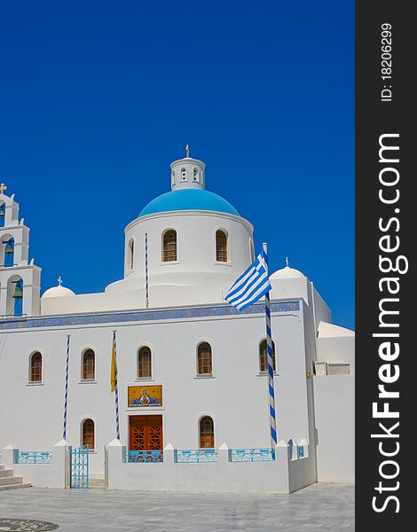 Beautiful white belfry of greek church on island of Santorini in Oia, Greece. And square with greece national flag. Beautiful white belfry of greek church on island of Santorini in Oia, Greece. And square with greece national flag