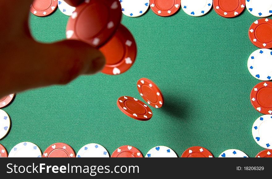 Red gambling chips falling from men hand