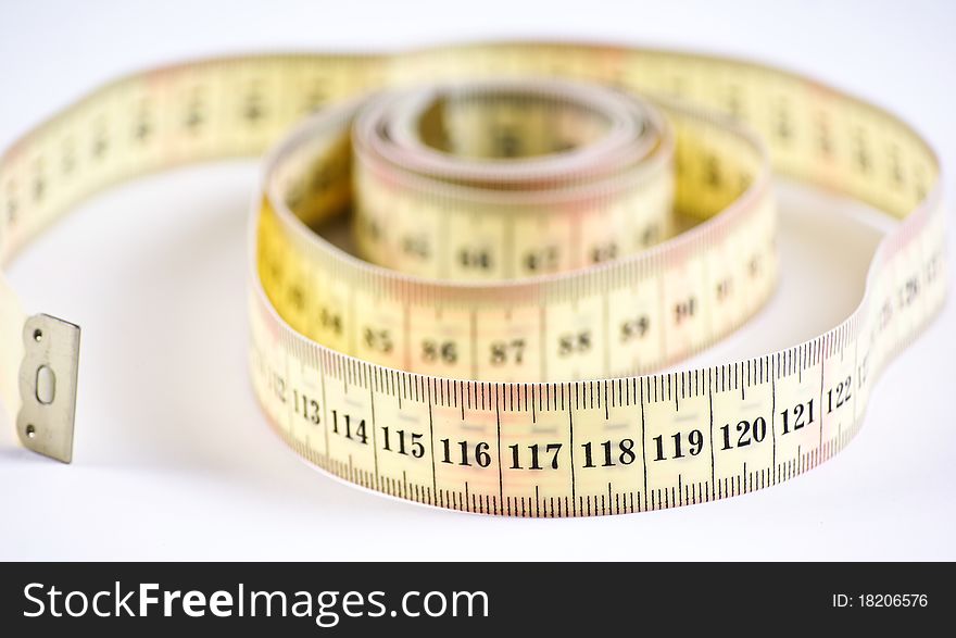 A yellow measuring tape on white background. A yellow measuring tape on white background