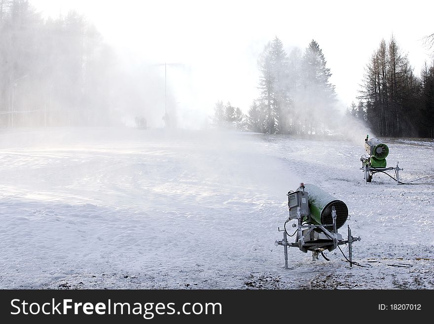 Snow cannons producing artificial snow on ski slopes. Snow cannons producing artificial snow on ski slopes.