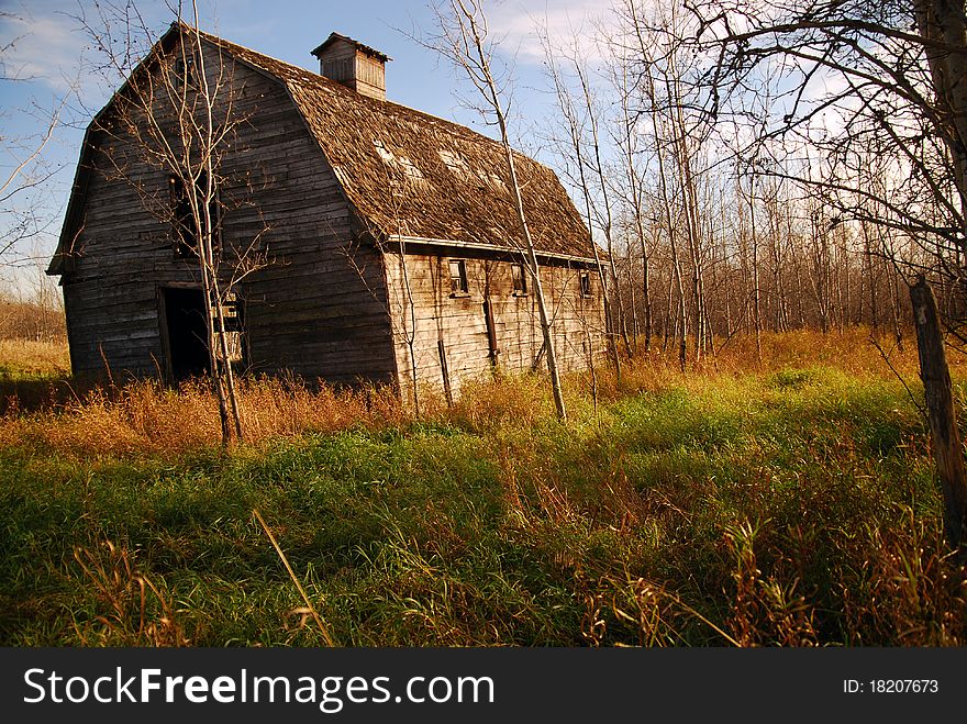 An old brown barn surrounded in sunlight. An old brown barn surrounded in sunlight