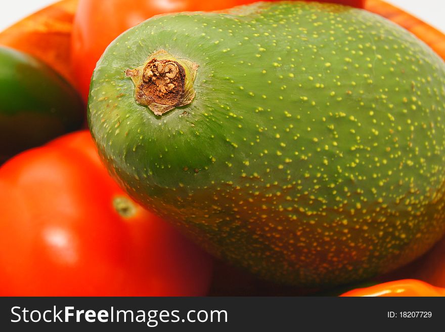 Close up of avocado with other fruit in the background