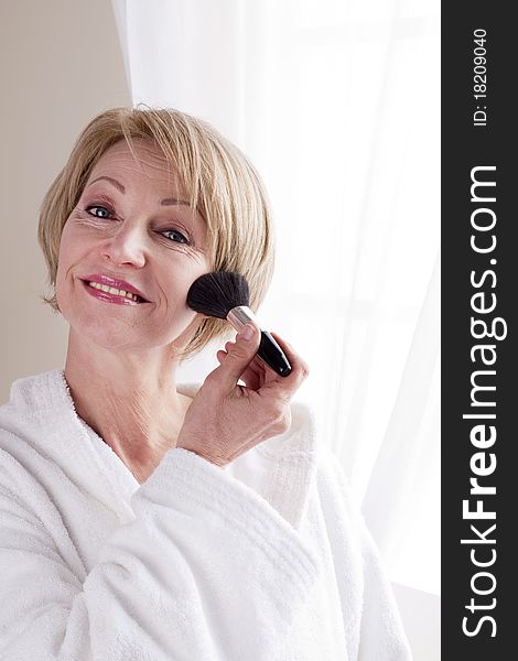 Mature Woman applying face powder. Mature Woman applying face powder