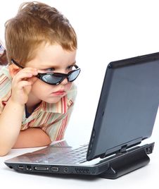 A Cute Boy Is Typing On A Laptop Stock Images
