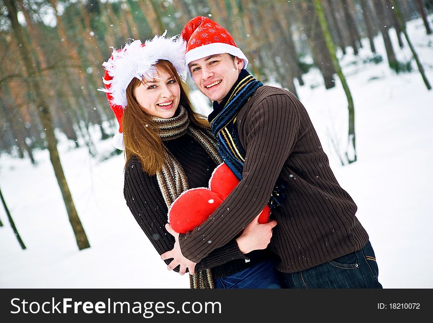 Couple in love with a red heart and Christmas Hats