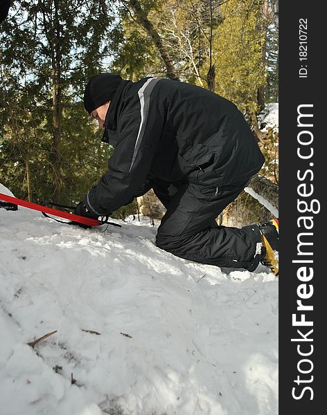 A man setting up webbing for a top rope repel for ice climbing. A man setting up webbing for a top rope repel for ice climbing.