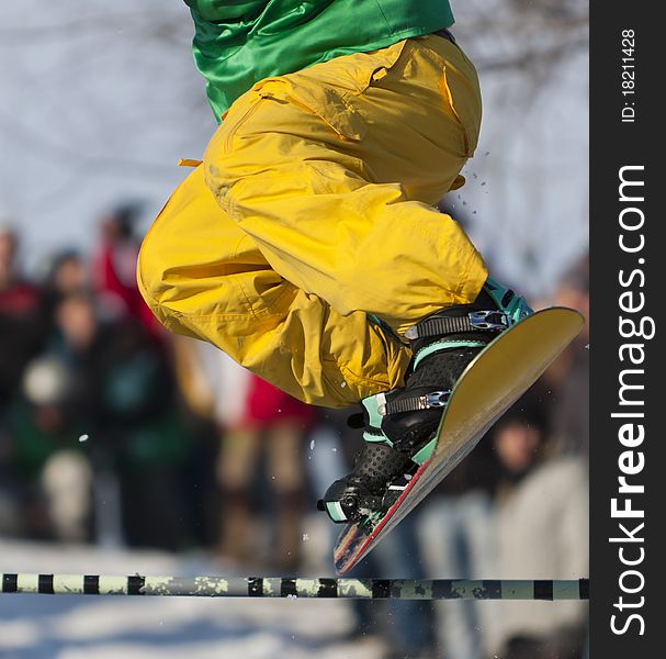 Snowboarder jumping over a beam