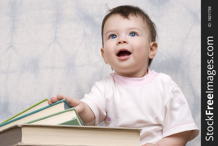 The small child with books on a light background