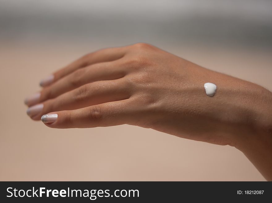 Sunblock on a female hand on the background of the beach. Sunblock on a female hand on the background of the beach