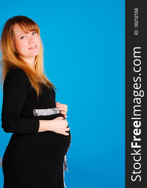 Beautiful pregnant woman staying on blue background