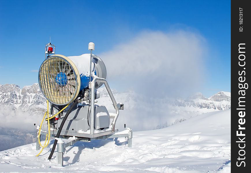 Snow cannon producing snow in the swiss alps