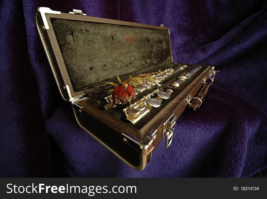 A side flute in wooden case with a rose. A side flute in wooden case with a rose.