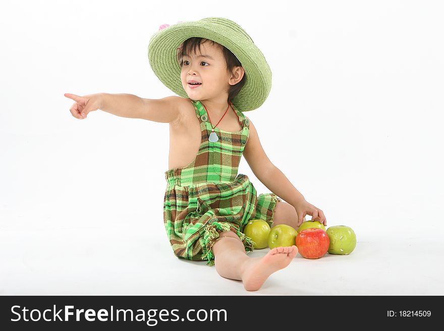 A girl with a green hat is playing some apples. A girl with a green hat is playing some apples.