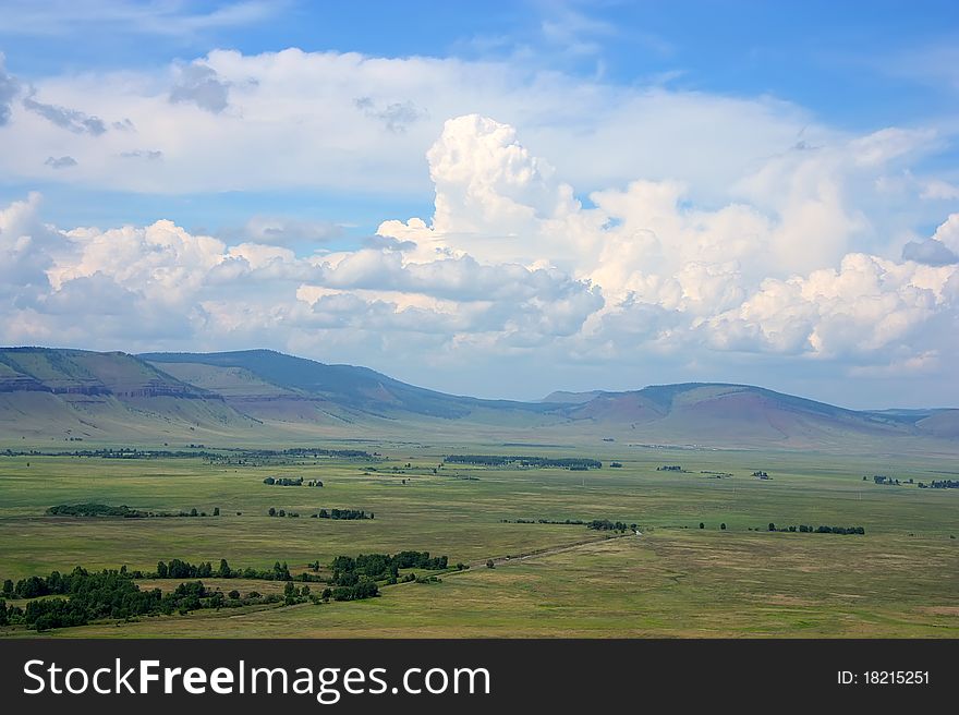 Green field, clouds and mountain in summer. Green field, clouds and mountain in summer