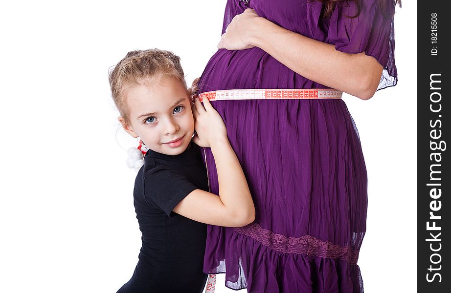 A cute girl measures the belly of her mother. isolated on a white background. A cute girl measures the belly of her mother. isolated on a white background