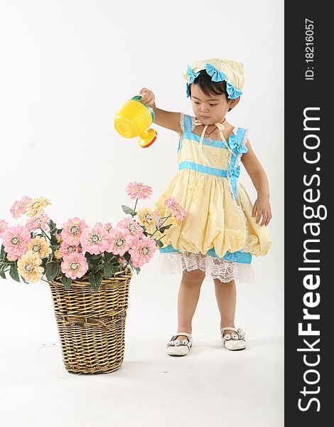 Little girl  with a sprinkler is  watering flowers just as a gardener 。. Little girl  with a sprinkler is  watering flowers just as a gardener 。