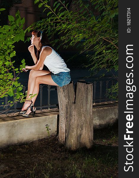 Portret photo of beautiful girl siting on the stump