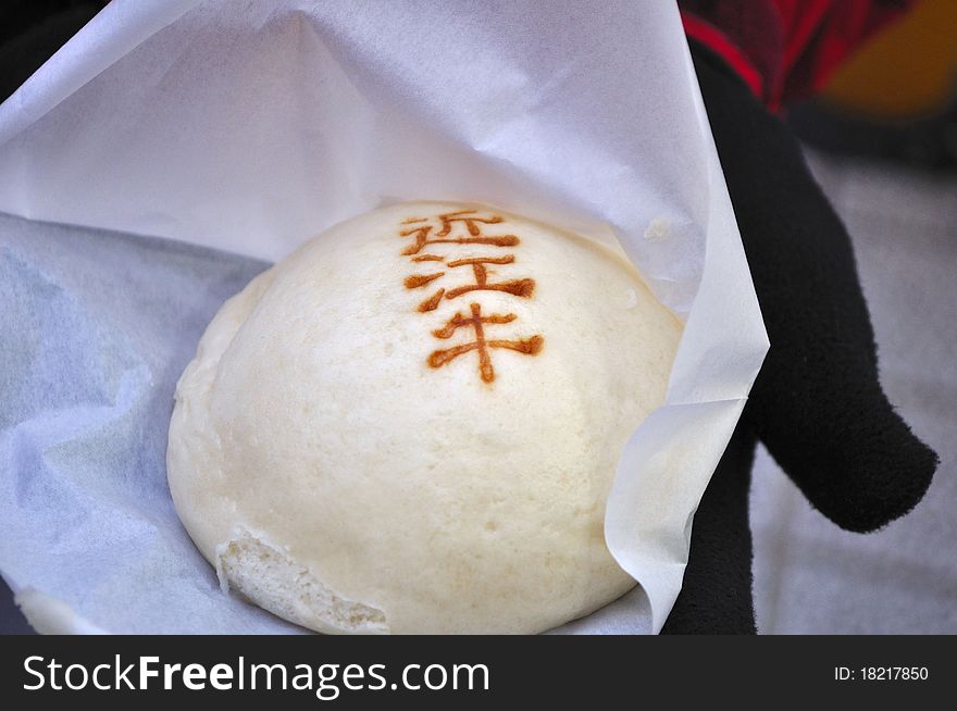 A closeup of a freshly steamed bun filled with Omi (Kobe) Beef from Japan. The words on the bun read 'Omi Beef'. A closeup of a freshly steamed bun filled with Omi (Kobe) Beef from Japan. The words on the bun read 'Omi Beef'.