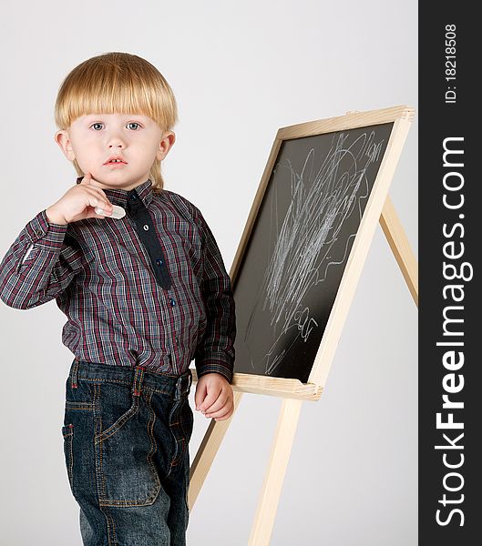 Little boy draws with chalk something on blackboard. Little boy draws with chalk something on blackboard