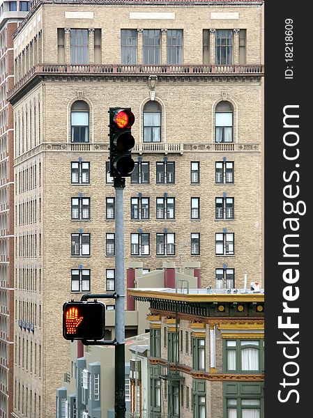 Details of an electric traffic light with a modern building in the background.