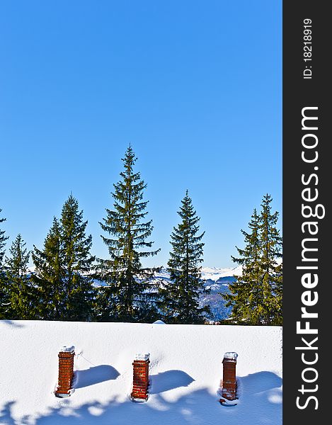 Roof house with three chimneys on winter mountain scenery
