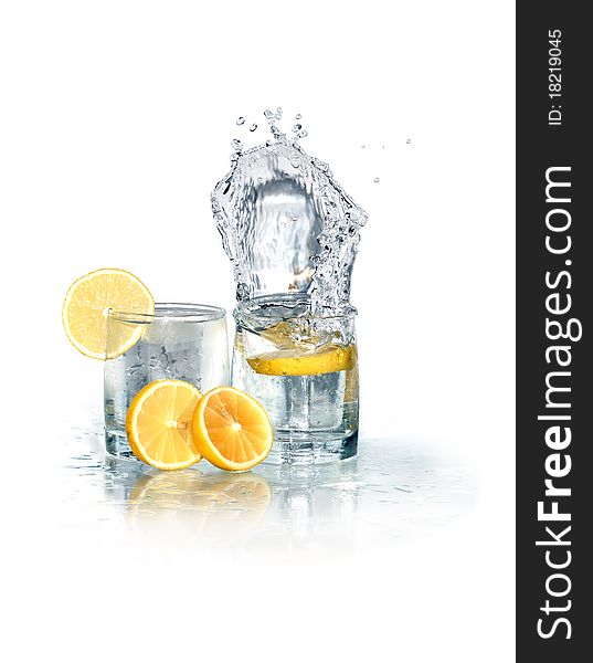 Two glasses of splashing water with ice and lemon. Isolated on white with clipping path. Two glasses of splashing water with ice and lemon. Isolated on white with clipping path