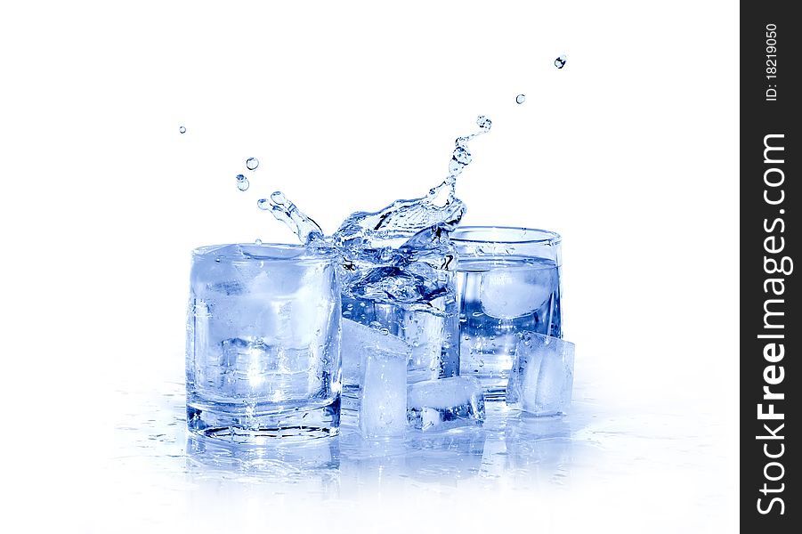 Few glasses of cold splashing water near ice cubes isolated on white with clipping path. Few glasses of cold splashing water near ice cubes isolated on white with clipping path