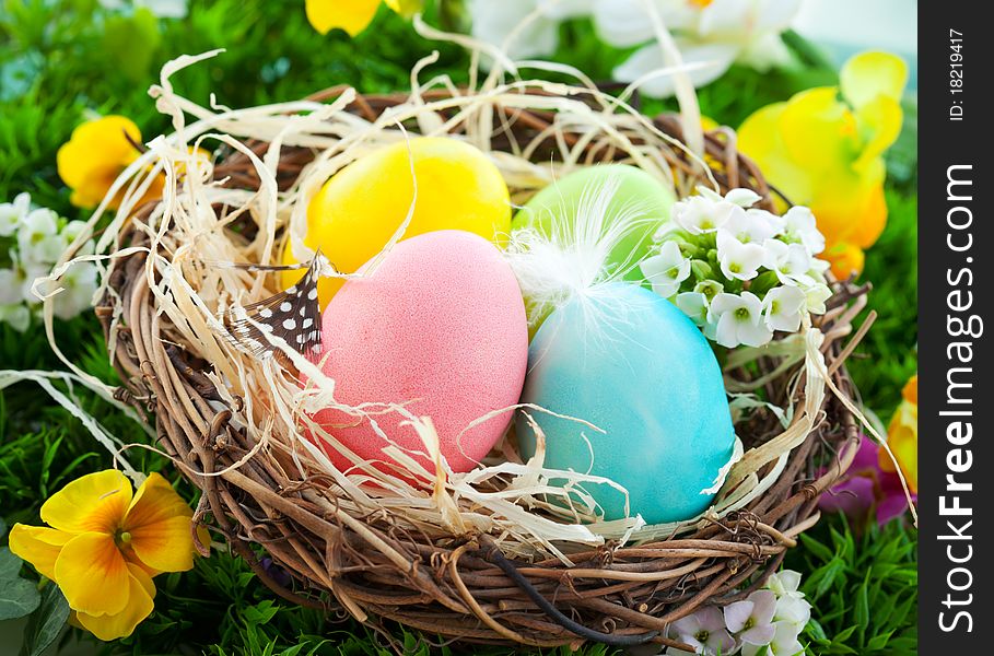 Colorful Easter Eggs in a nest on the grass